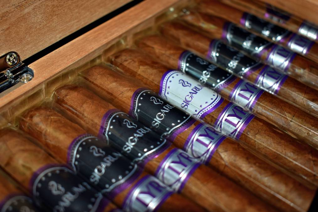Open box of LYRA cigars, black and purple SIGARUM 7 bands with one white band among them
