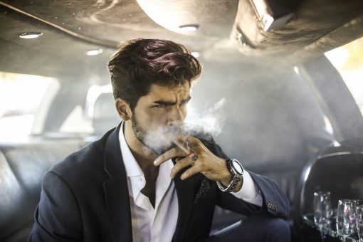 Businessman driving in a limousine. About 30 years old, Caucasian male.